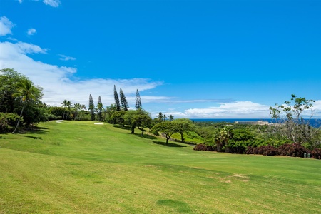 Rolling fairways with trees and ocean views.