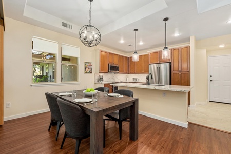 Gather around your beautiful dining table in this open-concept kitchen, perfect for memorable meals with warm wood finishes and modern amenities.