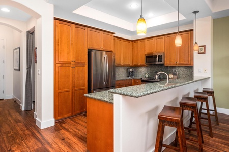 Full kitchen with breakfast bar, granite counters, and stainless steel appliances