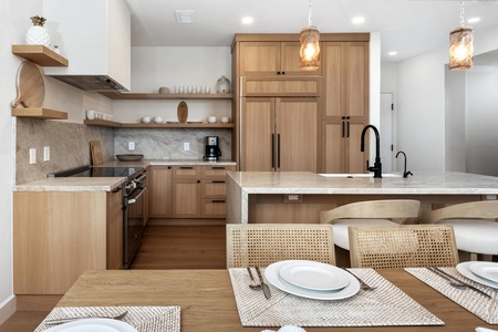 Your gourmet kitchen features warm wood cabinetry, marble countertops, and modern appliances perfect for cooking memorable meals together.