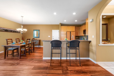 Gather around the spacious dining area or cozy up to the breakfast bar, where warm wood tones and open-concept living invite you to feel right at home.