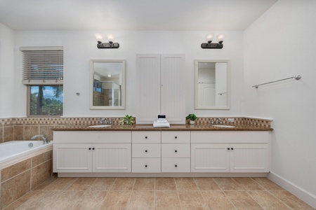 Unwind in your spacious master bathroom with dual sinks, soaking tub, and elegant tile work creating a spa-like retreat.