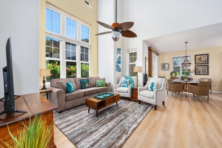 Bright, spacious living room with vaulted ceiling and tall windows