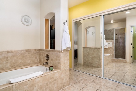 Corner bathroom includes a soaking tub and full mirrored closet.