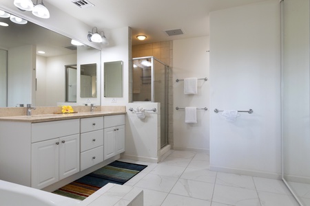 Ensuite bathroom with double vanity, walk in shower, and tub