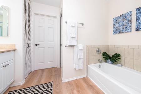 Ensuite primary bathroom with double vanity, walk-in shower, and tub