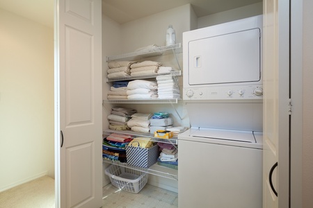 - In unit laundry features a stacked washer and dryer with open shelving stocked with towels and linens - Perfect for longer stays or freshening up beachwear - Convenient and essential amenity for easy vacation living