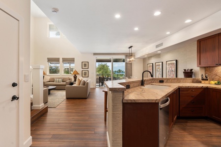 Your open-concept kitchen flows seamlessly into the living space, where marble countertops and warm wood floors create an inviting atmosphere for cooking and relaxing.