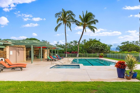 Spacious pool deck with palm trees and beautiful green surroundings.