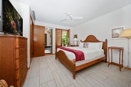 - Tranquil queen bedroom with solid wood furnishings and neutral tile floors - Private glass doors open to a peaceful garden patio view - Ceiling fan and thoughtful lighting make this space cool, calm, and restful