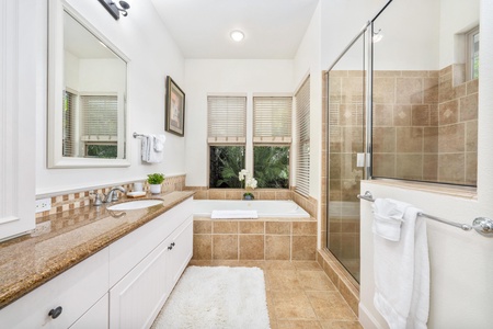 Your luxurious bathroom retreat features a soaking tub, separate glass shower, and serene garden views for ultimate relaxation.