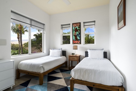 - Twin bedroom with crisp white linens and modern geometric rug design   - Large windows fill the space with light and views of beautiful greenery   - Comfortable setup perfect for friends children or extra guests