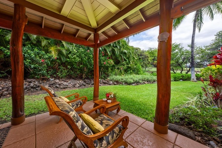 - Relaxing lanai with cushioned chairs overlooking beautiful green landscaping - Wooden posts and beams add a tropical touch to the covered space - Perfect for enjoying morning coffee or peaceful afternoon views