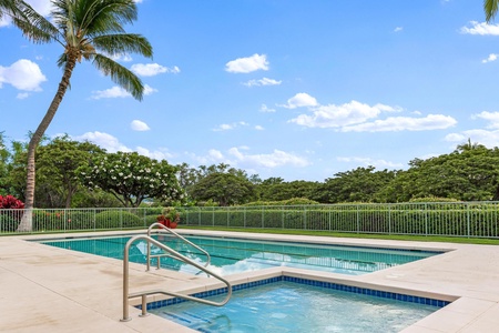 Inviting hot tub beside the pool with peaceful garden views.