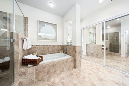 Ensuite primary bathroom with double vanity, walk-in shower, and soaking tub