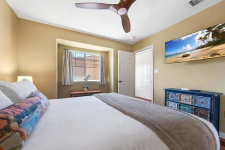 Sink into crisp linens and let the ceiling fan's gentle breeze lull you to sleep in your serene bedroom retreat.