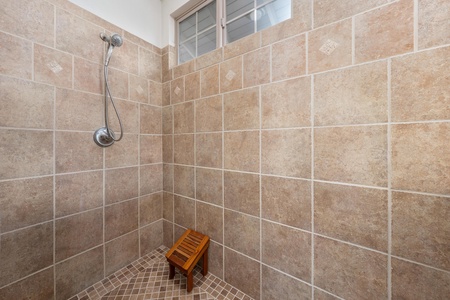Step into your private tiled shower with natural light streaming through the window, creating a bright, spa-like retreat for your daily refresh.