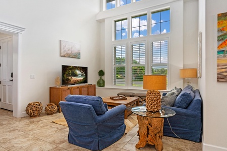 Living room with vaulted ceiling and tall windows