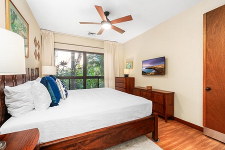 Drift off in your peaceful bedroom where tropical views frame your window and warm wood tones create a cozy retreat.