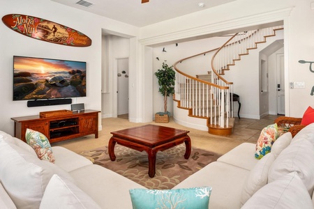 - Watch your favorite shows on the flat screen from the cozy corner sofa - Unique surfboard decor and warm wood tones create a laid back vibe - Grand staircase adds architectural elegance to this inviting space