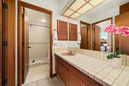 Your spacious bathroom features warm wood accents, tile counters, and a separate shower for refreshing mornings.