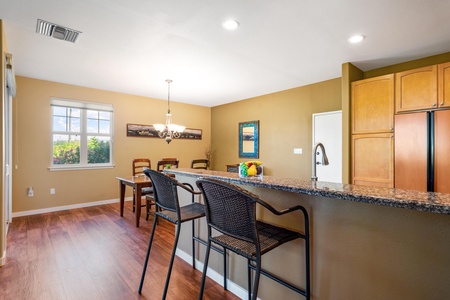 Step into your bright, open kitchen and dining space—perfect for preparing meals at the granite breakfast bar or gathering around the table with loved ones. Warm wood floors and natural light make this feel like home.