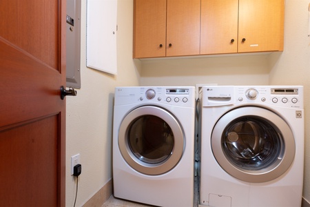 - Laundry room with modern front load washer and dryer for guest convenience   - Overhead cabinets provide storage for cleaning supplies and essentials   - Located for easy access during longer stays or family vacations