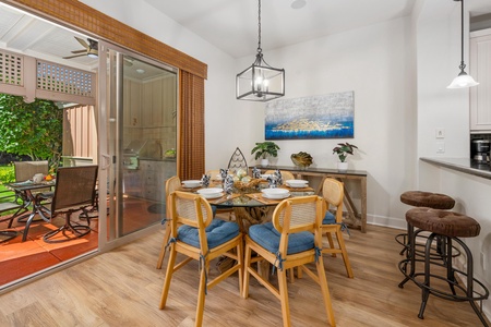 Your elegant dining space flows seamlessly to a private patio, perfect for memorable meals with ocean artwork inspiring conversation.
