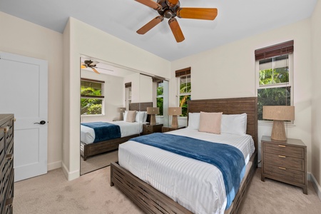 Drift into peaceful sleep in your bright bedroom with twin beds, gentle ceiling fan, and lush garden views.