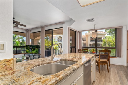 Your sunlit kitchen opens to a private balcony with tropical views, featuring elegant granite countertops, modern appliances, and a cozy dining nook perfect for morning coffee or evening meals.