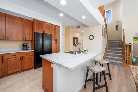 Full kitchen with breakfast bar, granite counters, and modern appliances
