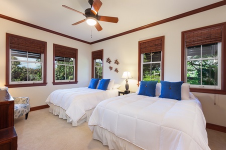 - Bright bedroom with two plush beds topped with crisp white linens and blue accent pillows - Large windows bring in natural light and views of beautiful greenery - Ceiling fan adds comfort while tasteful decor enhances relaxation
