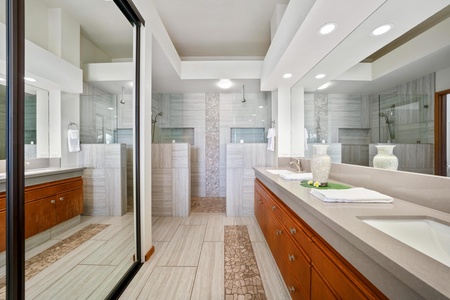 - Stylish ensuite bath features dual walk in rainfall showers with tile and stone details - Full length mirrors, recessed lighting, and modern fixtures enhance the spa like feel - Serene oasis steps from the bedroom for total convenience