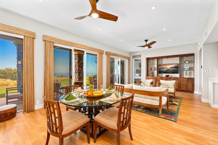 - Dining space with glass top table set for four & natural wood chairs for comfort - Open layout flows into living area with ceiling fans & large windows for breezy charm - Sliding doors offer access to patio with scenic views of the surrounding landscape