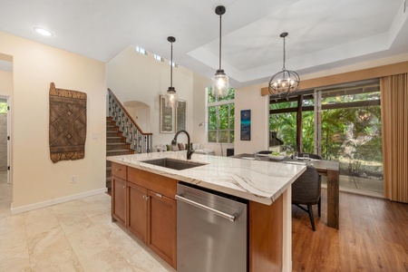 Your spacious kitchen island becomes the heart of your stay, where marble countertops and modern appliances meet warm wood tones for effortless meal prep.