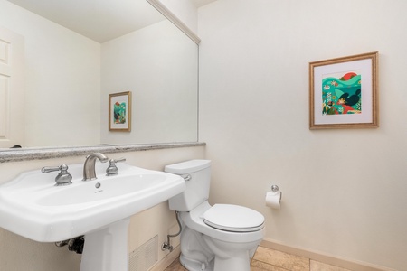 Your private powder room offers elegant touches with tropical artwork and a pedestal sink for convenient freshening up.