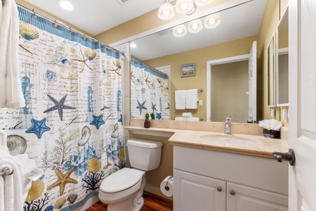 Step into your private bathroom, where coastal charm meets everyday comfort. Warm tones, ample lighting, and thoughtful touches like fresh towels create a welcoming retreat after a day of beach adventures.