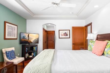 - Bedroom with king bed, TV, and arched doorway to ensuite bathroom - Warm wood doors and trim add contrast to the fresh, bright design - Hardwood floors complete the inviting and comfortable atmosphere