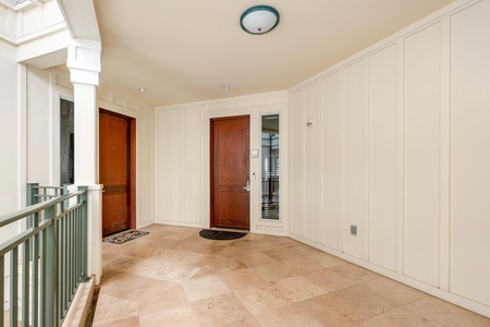 A welcoming shared entrance with elegant tiled floors and classic wood doors, leading to your private retreat within the property.