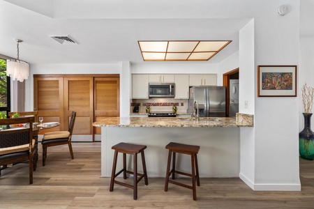 Your open-concept kitchen invites relaxed island dining and easy entertaining, with stainless steel appliances, granite countertops, and warm wood accents throughout.