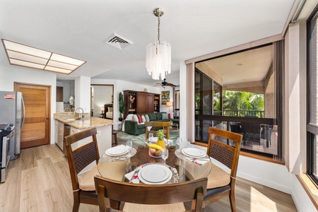 Gather around the elegantly set table where natural light pours through skylights and tropical breezes drift in from your private balcony, creating the perfect setting for shared meals.