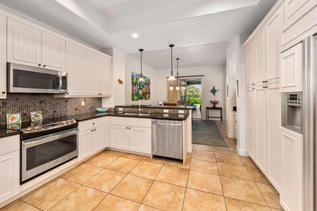 - Enjoy an open kitchen layout that flows effortlessly into the dining area - Pendant lighting adds style over the granite breakfast bar and sink - Ideal setup for entertaining, snacking, or chatting while cooking