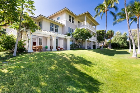 Spacious lawn with a two story home and covered patios.