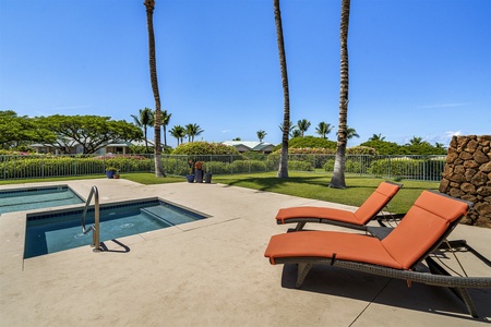 Hot tub with serene palm and garden backdrop.