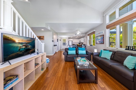 - Open concept layout blends the living room, dining area, and kitchen seamlessly - Teal pillows pop against leather sofas for a fresh island inspired touch - Natural light pours in through tall windows lining the entire space