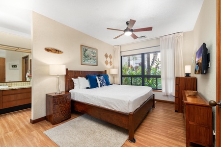 Unwind in your tropical bedroom with rich wood furnishings, crisp linens, and garden views through floor-to-ceiling windows.