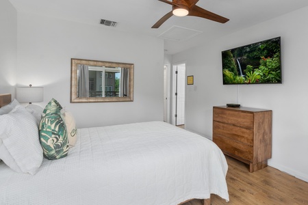 Rest easy in this bright bedroom with comfortable bed and TV.