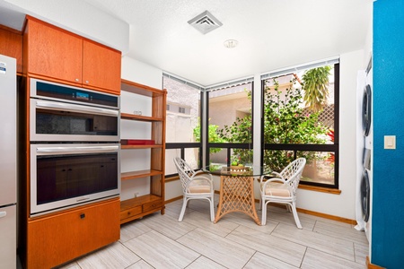 - Cozy breakfast nook tucked beside bright windows and tropical greenery - Glass top table and wicker chairs provide the perfect setting for casual bites - Ideal spot to enjoy your morning coffee with serene courtyard views