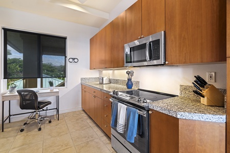 - Sleek kitchen with granite counters and modern stainless steel appliances   - Warm wood cabinetry provides plenty of storage for all your cooking needs   - Bright window view adds natural light to this functional workspace