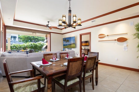 - Elegant dining room with wood furnishings and decorative paddle wall art   - Flows seamlessly into the living area with a large flat screen TV   - Natural light and warm tones create an inviting atmosphere for meals